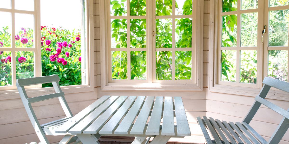 sunny porch room with table and chairs and the window in open