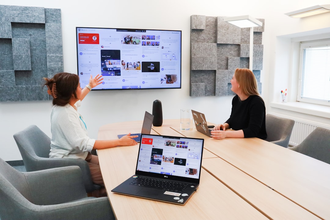 Two business professionals in a bright, modern office finalize an agreement with a firm handshake, symbolizing the trust a...