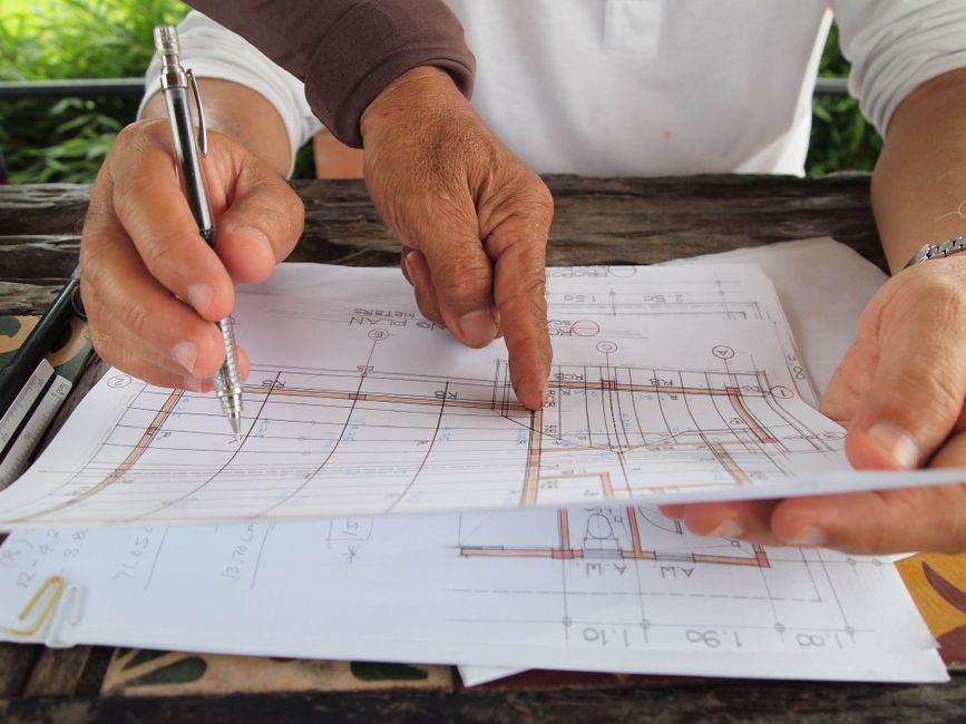 An architect's desk with technical blueprints and a drafting compass, illustrating the precision and structure required for advanced technical SEO and building digital trust.