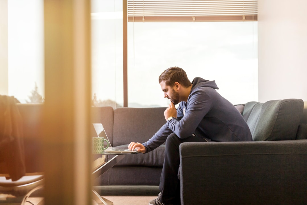 A business professional in a bright, modern office calmly points to information on a laptop screen, representing the proactive process of correcting and managing a business's online information.