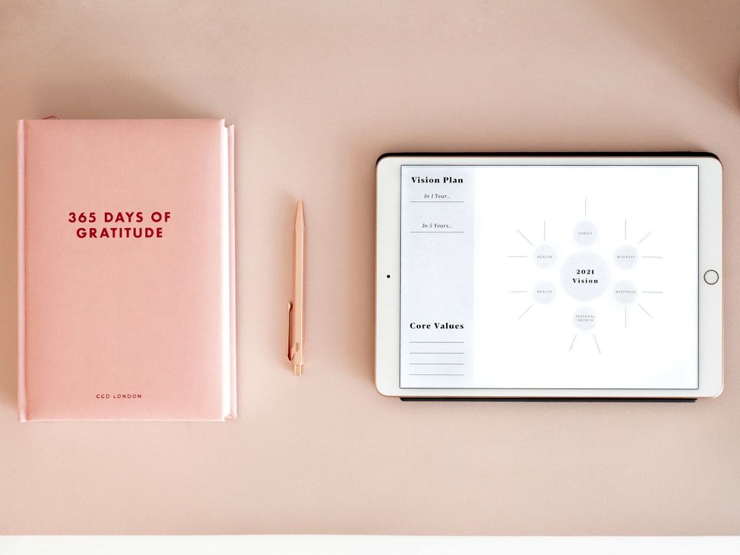 A close-up of a person's hands scrolling through information on a tablet at a clean, minimal desk, representing modern digital research into a realtor's sales history.