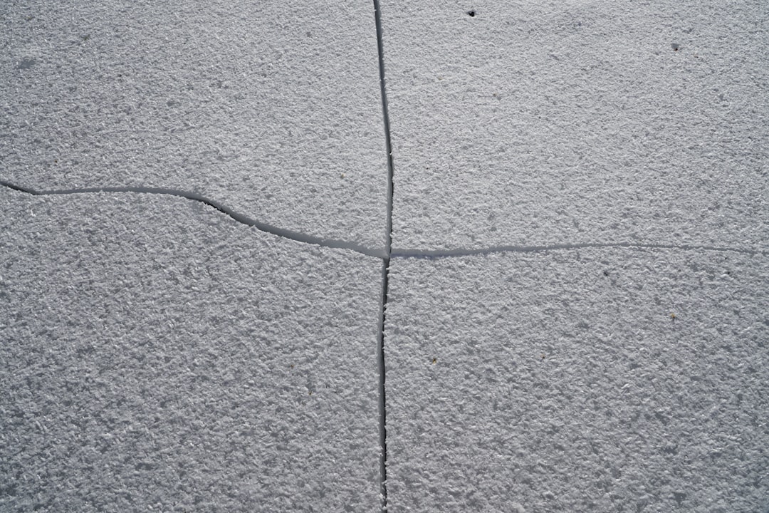 A close-up of a significant crack in the concrete foundation of a modern home, representing the hidden structural risks of hiring a discount broker.