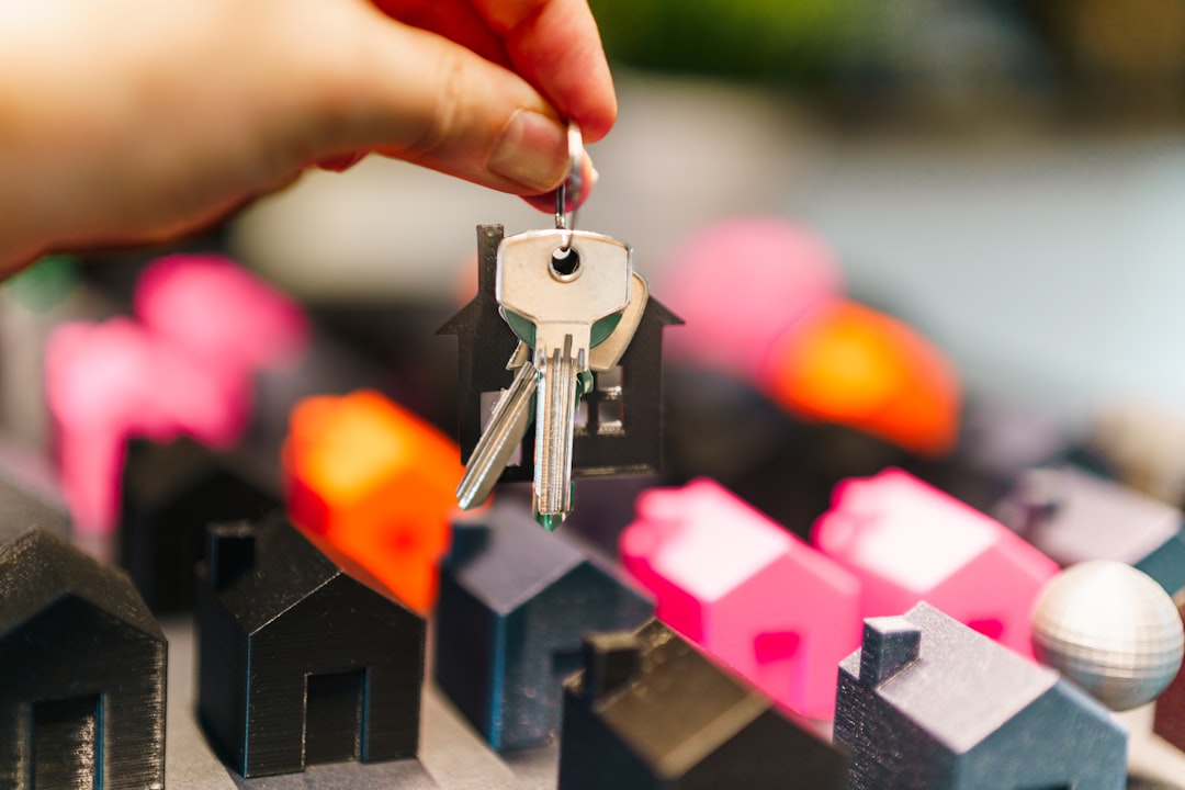 A sharply dressed individual stands confidently holding a set of keys inside a modern home with clean lines, representing a successful, well-researched real estate transaction.