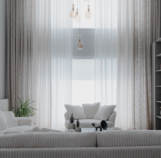 Bright and airy modern luxury living room with minimalist furniture and large windows, showcasing a home prepared for a hi...