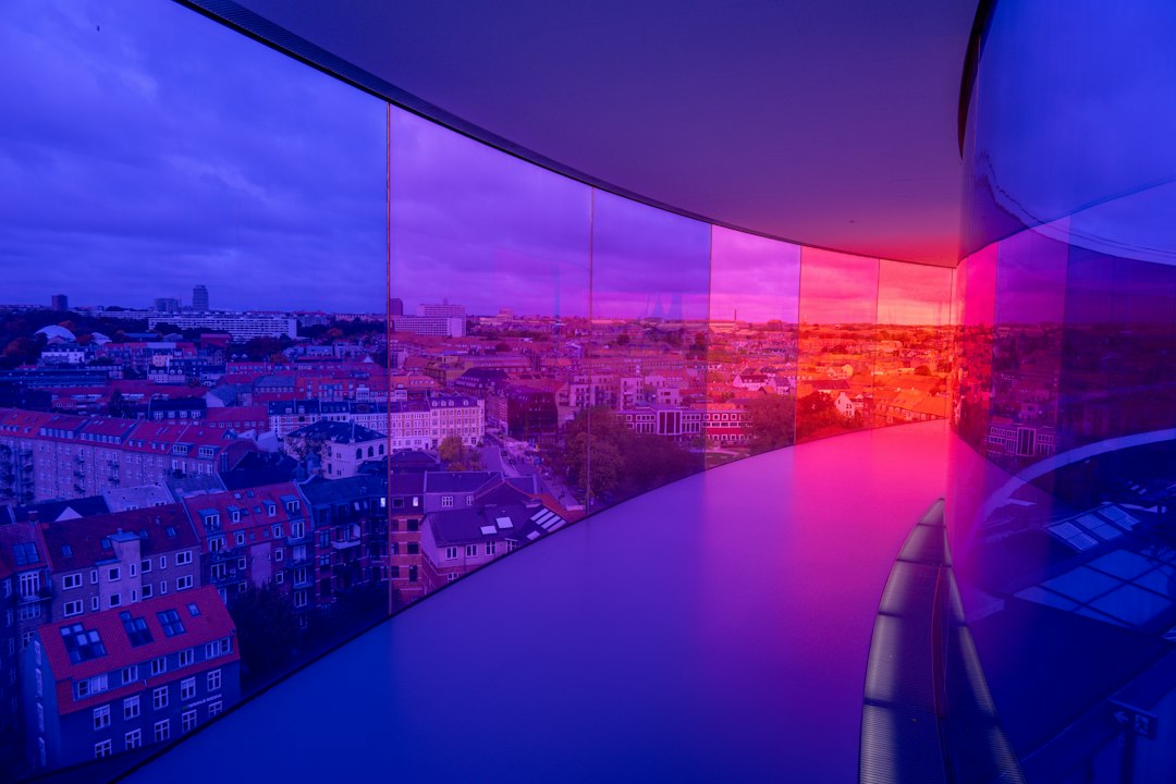 Business professional in a modern setting touching a transparent screen displaying a glowing, futuristic data interface, s...