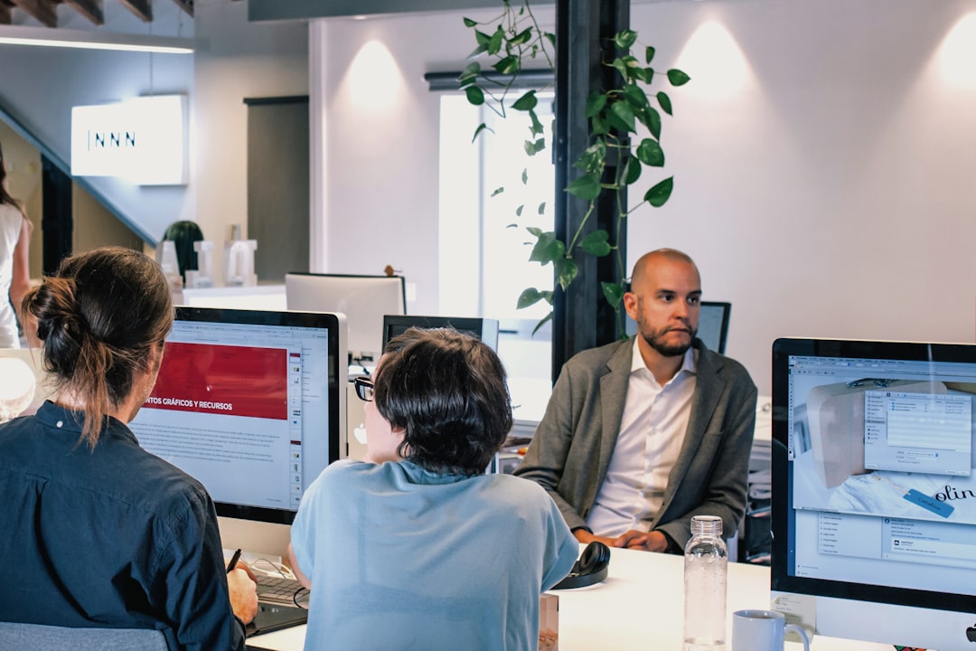 A diverse team of real estate professionals collaborates around a conference table in a bright, modern office, showcasing teamwork and specialized expertise.