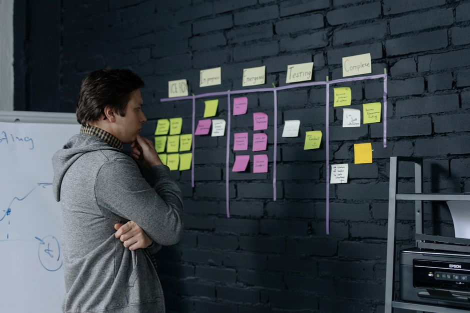 Real estate entrepreneur in a modern, bright office thoughtfully planning a nationwide business strategy on a large map of...