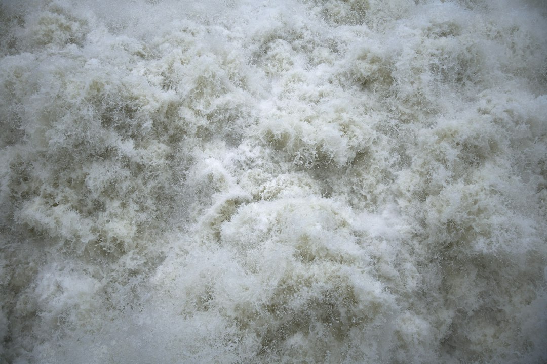 A detailed macro shot showing the clean, white, expanding texture of spray foam insulation, highlighting its ability to create an airtight seal.